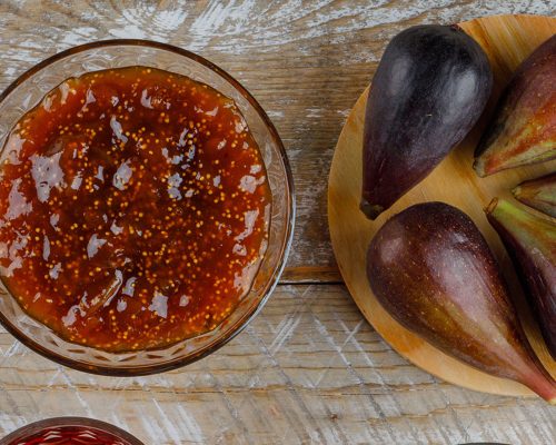 NOVOfigs-with-tea-fig-jam-teaspoon-bowl-wooden-cutting-board-flat-lay